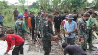 Prajurit Satgas Yonif 131/Brs Bersama Warga Bersihkan Sungai dan Jembatan Akibat Banjir